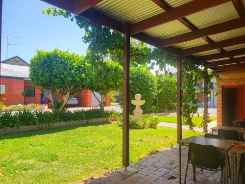 a patio with a table and chairs under a pergola at Wentworth Central Motor Inn in Wentworth