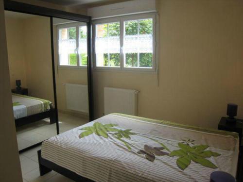 Schlafzimmer mit einem Bett und einem Fenster in der Unterkunft La Résidence des Fleurs in Lecelles