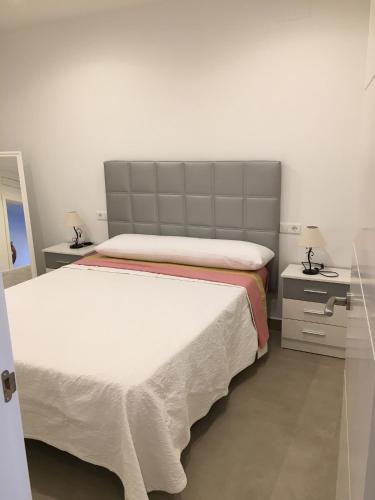 een slaapkamer met 2 bedden en 2 nachtkastjes bij apartamento cristina in El Rompido