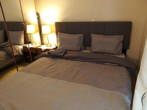 duże łóżko w pokoju z dwoma lampami w obiekcie Maria’s house w Salonikach