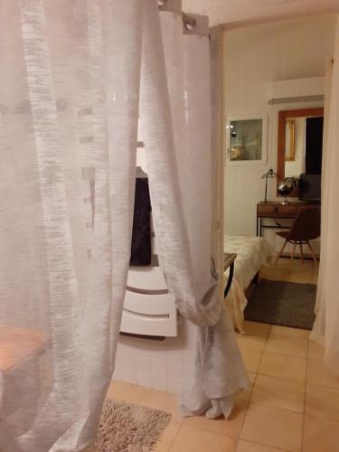 um quarto com cortinas brancas e uma cama em La Bergerie em Lagarrigue
