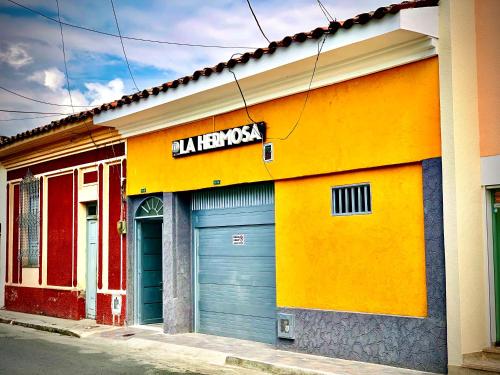 a building with two garage doors and a sign on it at La Hermosa Hotel in Buga
