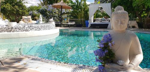 een beeld van een vrouw met bloemen naast een zwembad bij Casa privada para dos con Jacuzzi y Piscina Málaga in Alora