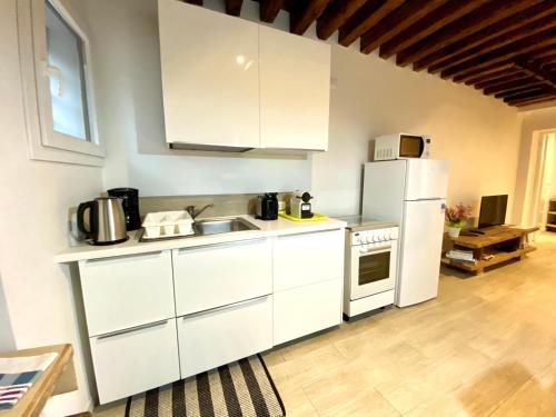 a white kitchen with a sink and a refrigerator at SANTA CATERINA in Venice