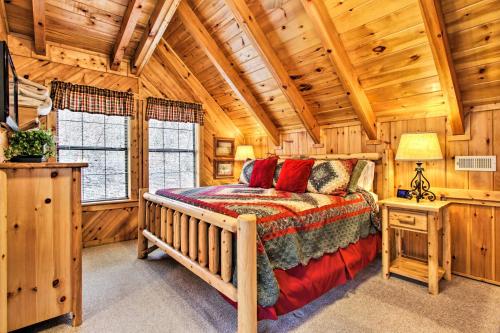 a bedroom with a bed in a log cabin at Gatlinburg Mountainside Escape with Deck and Hot Tub! in Gatlinburg
