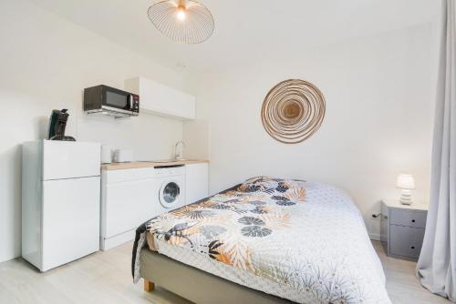 - une chambre blanche avec un lit et un réfrigérateur dans l'établissement Studios Nancy GARE - STANISLAS, à Nancy