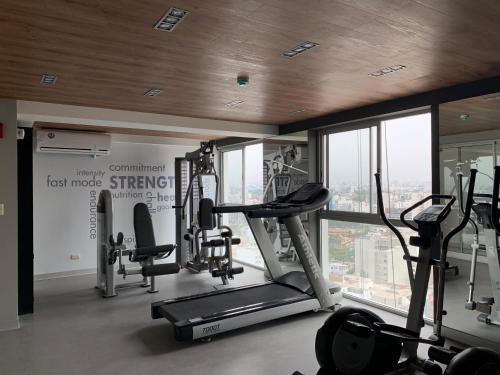 a gym with treadmills and ellipticals in a building at Connect in Lima