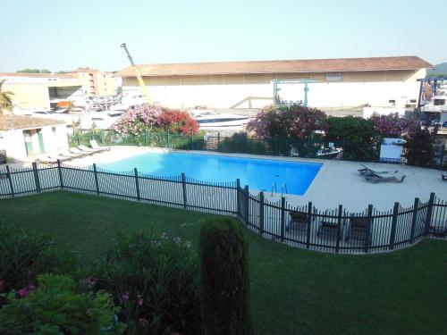 a fence around a swimming pool in a yard at Luxury apartment in Port Grimaud in Grimaud