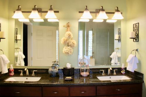 La salle de bains est pourvue de 2 lavabos et d'un grand miroir. dans l'établissement Maple Creek Bed&Breakfast, à Tomball