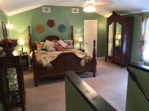 a bedroom with a bed and green walls at Maple Creek Bed&Breakfast in Tomball