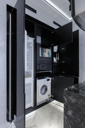 a black and white kitchen with a washer and dryer at White Tiger Apartment in Smart Plaza in Kyiv