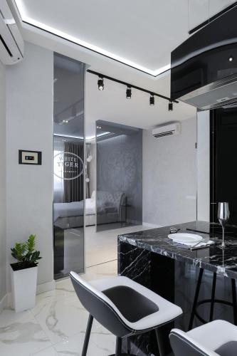 a kitchen with a counter and a table and chairs at White Tiger Apartment in Smart Plaza in Kyiv