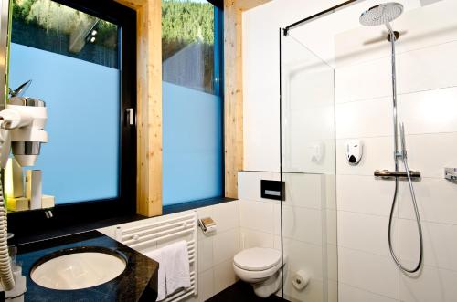 a bathroom with a shower and a toilet and a sink at Astellina hotel-apart in Ischgl
