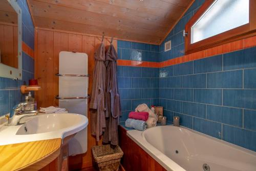 een badkamer met een bad en een wastafel bij Chalet Dreamtime in Les Villards-sur-Thônes