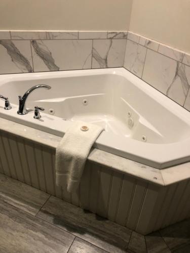 a white bath tub with a sink and a towel at Talbott Tavern and Inn in Bardstown