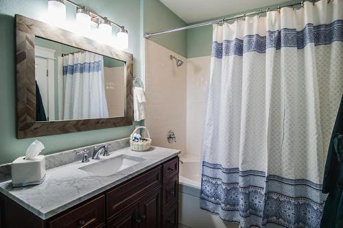 a bathroom with a sink and a shower curtain at The Campbell House Inn in Eugene