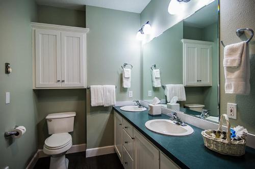 a bathroom with two sinks and a toilet and a mirror at The Campbell House Inn in Eugene