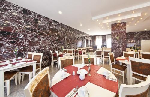 ドルトムントにあるHotel Unique Dortmund Hauptbahnhofの石壁のダイニングルーム(テーブル、椅子付)