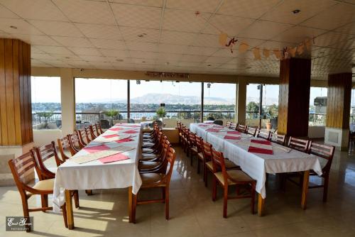 a large room with long tables and chairs and windows at Susanna Hotel Luxor in Luxor