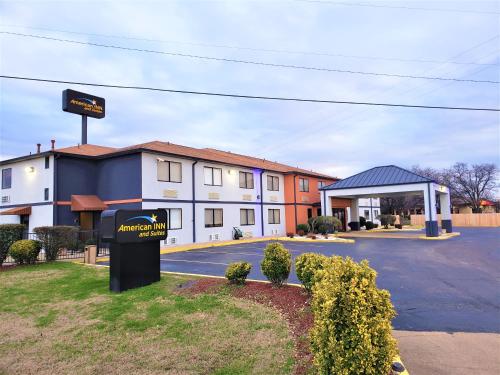 a hotel with a sign in front of a building at American Inn & Suites West Memphis in West Memphis