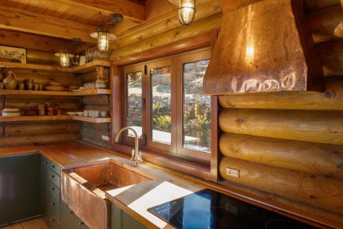 una cocina con fregadero y una ventana en una cabaña de madera en Lyford's Boutique Retreat - Relax & Enjoy, en Mt Lyford