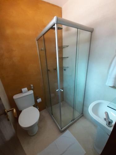 a bathroom with a shower and a toilet and a sink at Pousada da Pipa in Pipa