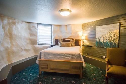 a bedroom with a bed and a chair in it at The Campbell House Inn in Eugene