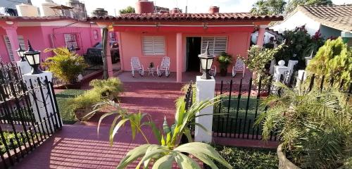 a pink house with a fence in front of it at El Campesino Yuri y Nino in Viñales