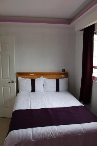 1 dormitorio con 1 cama grande con almohadas blancas y negras en Hotel Boutique Tonalli en San Martín de las Pirámides