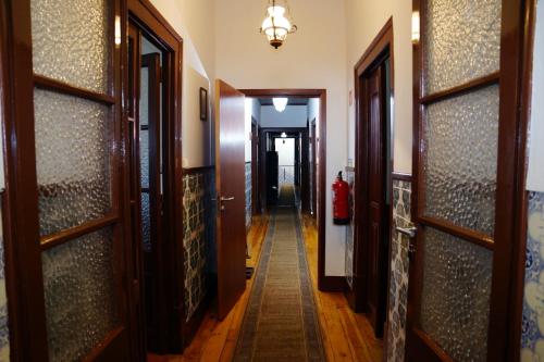 a hallway with wooden doors and a hallwayngth at Casa D'Avó Mila in Góis
