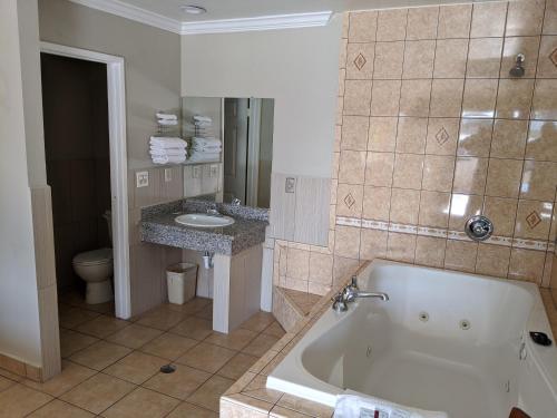 a bathroom with a tub and a toilet and a sink at Passport Inn in Whittier
