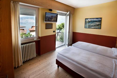 a bedroom with a bed and a large window at Ambienthotel Luna Rossa in Malcesine