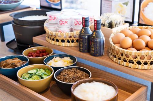 a buffet with bowls of food and eggs and other ingredients at Vessel Inn Keisei Tsudanuma Station in Narashino