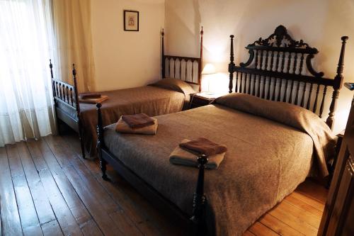 two beds in a bedroom with wooden floors at Casa D'Avó Mila in Góis