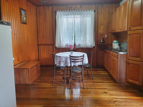 eine Küche mit einem Tisch und Stühlen sowie einem Fenster in der Unterkunft Casa de Ferias Dona Inês in Treze Tílias