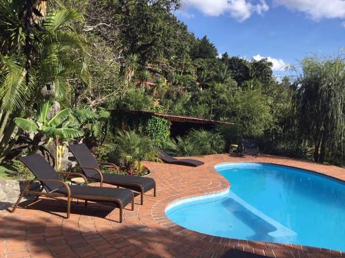 a swimming pool with lounge chairs next to a resort at Casa Hagan in Santa Cruz La Laguna