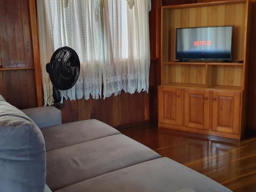 a living room with a couch and a tv at Casa de Ferias Dona Inês in Treze Tílias