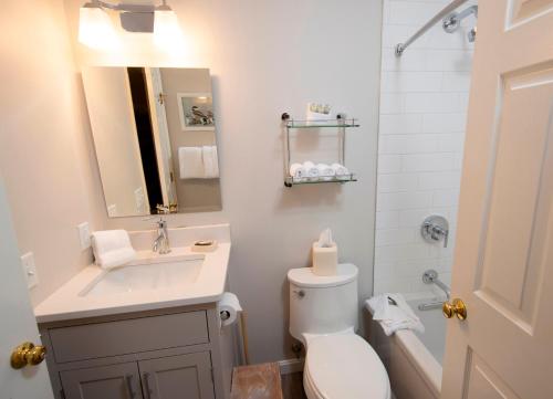 a bathroom with a sink and a toilet and a mirror at Modern & Updated Winterplace 3Br- Sleeps 12 condo in Ludlow