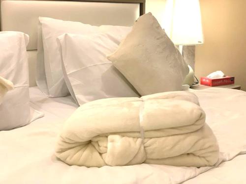 a large white blanket on a white bed at My Villa Abha in Abha