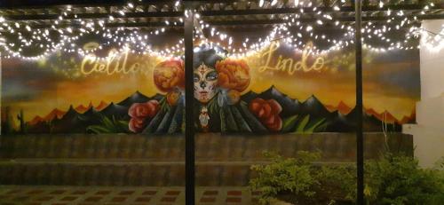 une peinture d'une vache sur un mur avec des lumières dans l'établissement CIELITO LINDO, à Santa Rosa de Cabal