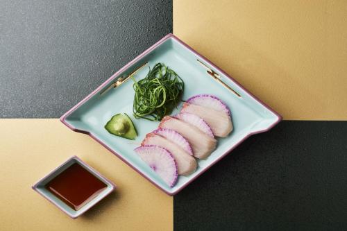 a plate of food with meat and vegetables on a table at Takamiya Ryokan Sagiya Sansorai in Kaminoyama