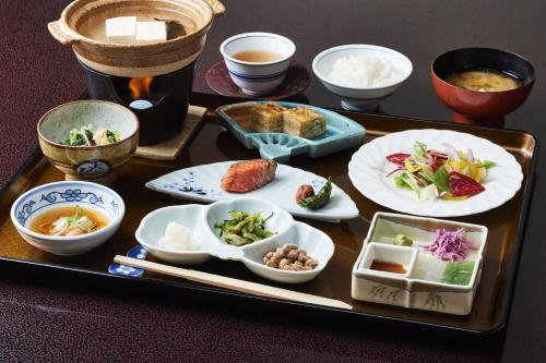 a tray with plates of food on a table at Takamiya Ryokan Sagiya Sansorai in Kaminoyama
