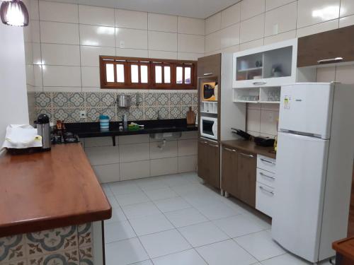a kitchen with a white refrigerator and a counter at Casa de Praia Luis Correia in Luis Correia