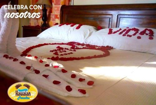 Una cama con un corazón hecho de corazones rojos en Hotel Hawaian Paradise, en El Hawaii
