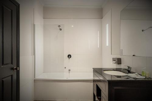 a kitchen with white cabinets and a white sink at Kryal Castle Ballarat in Ballarat