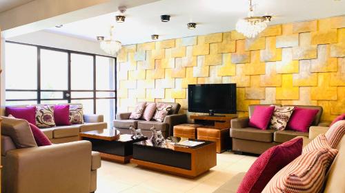 Arequipa Inn في أريكيبا: غرفة معيشة مع كنب وتلفزيون بشاشة مسطحة