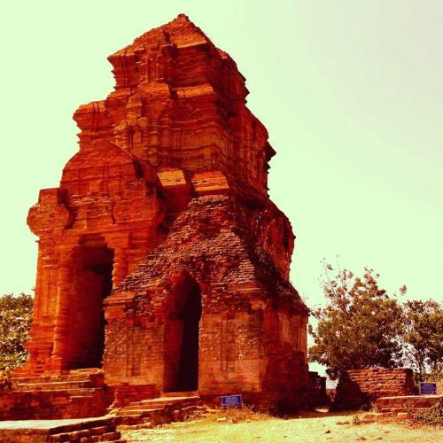 an old brick building with an arch in a field at The Cliff Residence in Mui Ne
