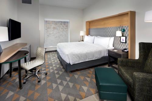 um quarto de hotel com uma cama, uma secretária e um computador em Holiday Inn & Suites Arden - Asheville Airport, an IHG Hotel em Arden