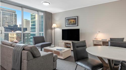 uma sala de estar com um sofá e uma mesa em Oaks Brisbane Festival Suites em Brisbane