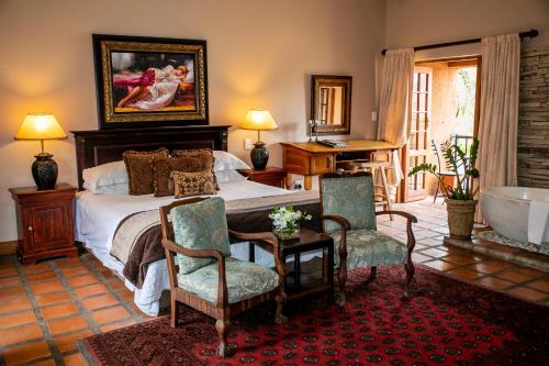 a bedroom with a bed and a tub in it at Terra Casa Guesthouse in Rustenburg
